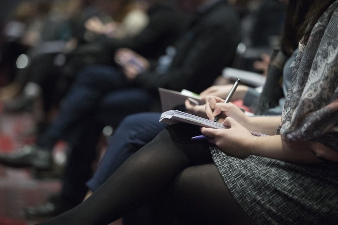 Participants taking notes during a seminar